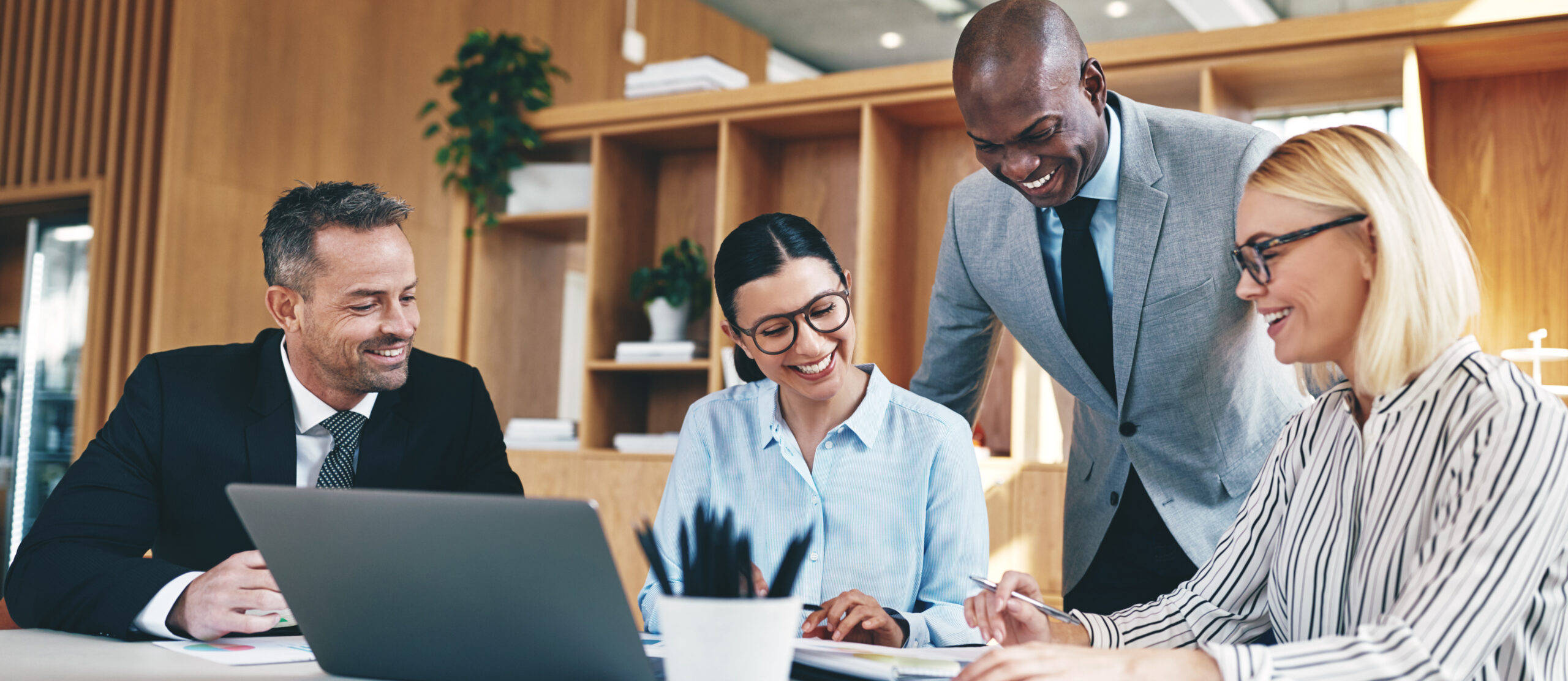 Diverse group of businesspeople laughing together during an office meeting