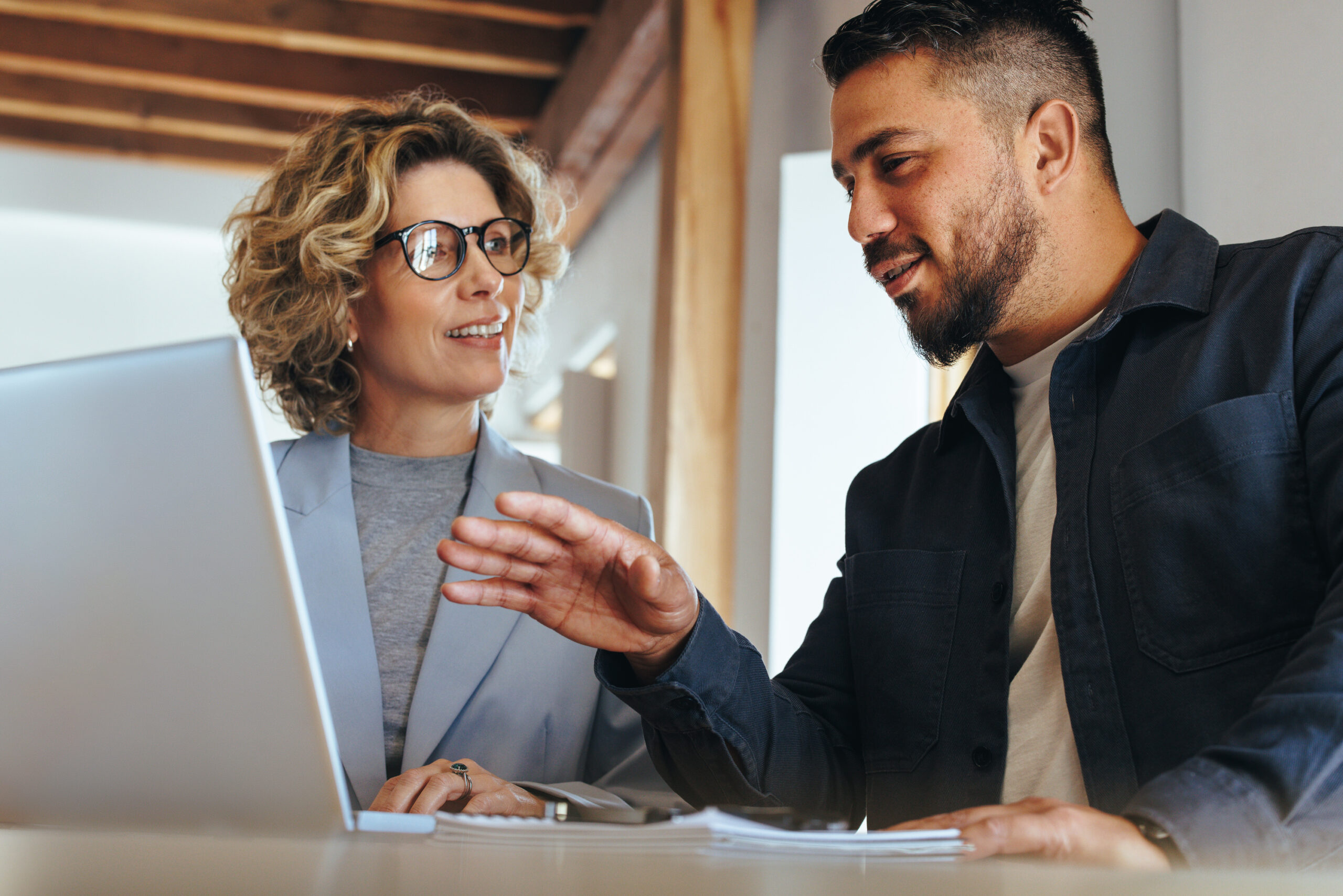 man and woman sitting at a computer talking about auditing bank reconciliations