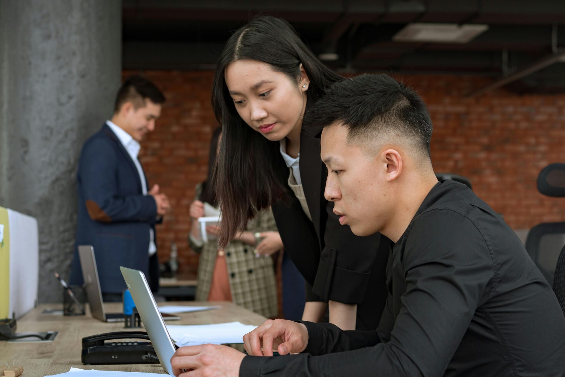 Two coworkers discussing the cash application process in a modern office setting