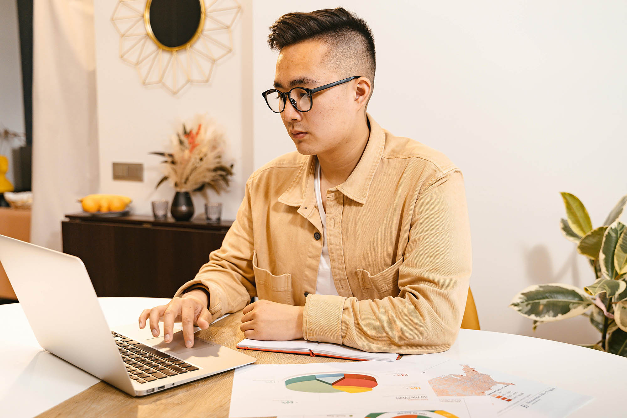 Finance analyst reviewing financial consolidation charts and reports on laptop