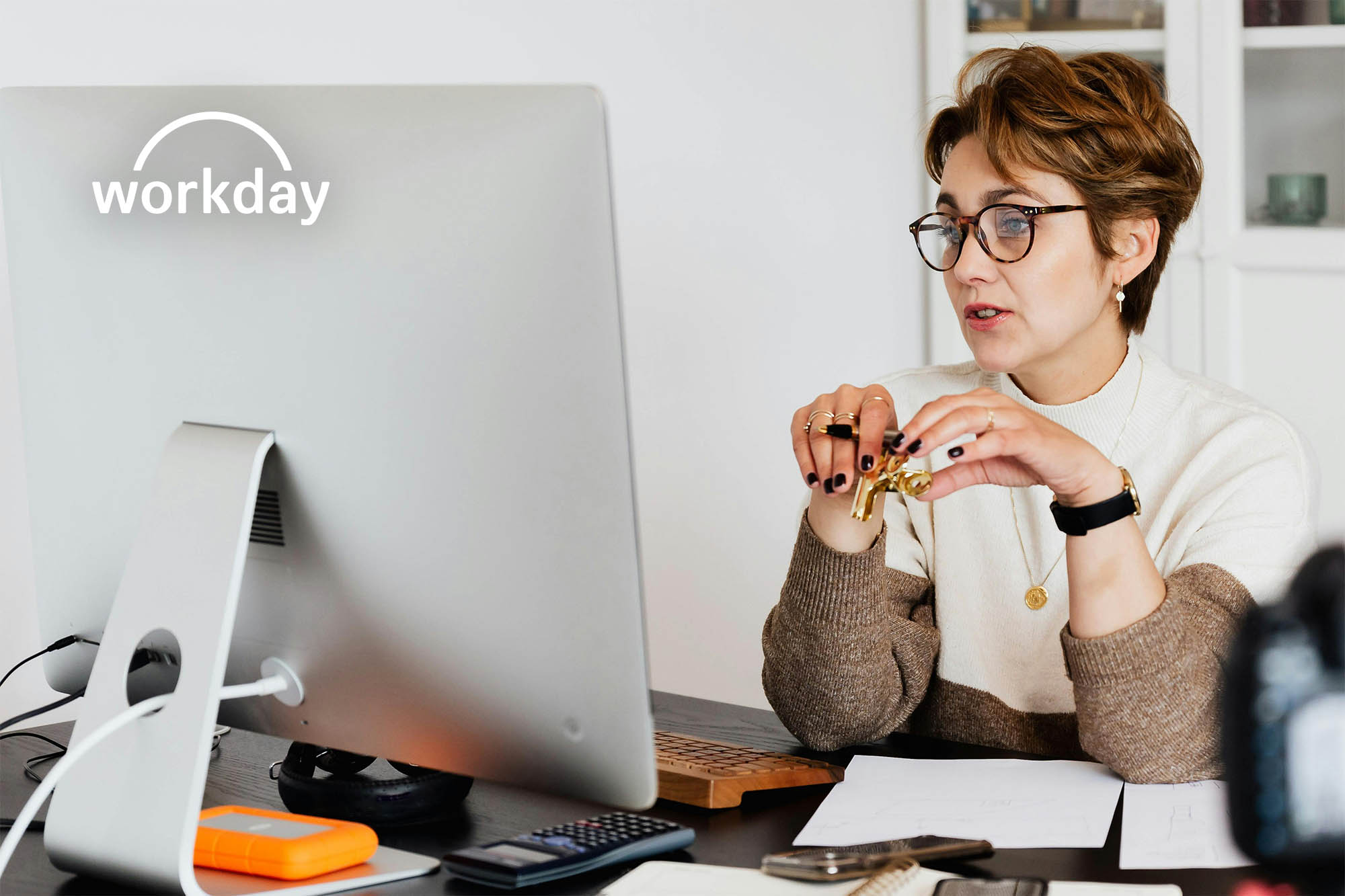 Healthcare professional reviewing financial reporting software using Workday system on desktop