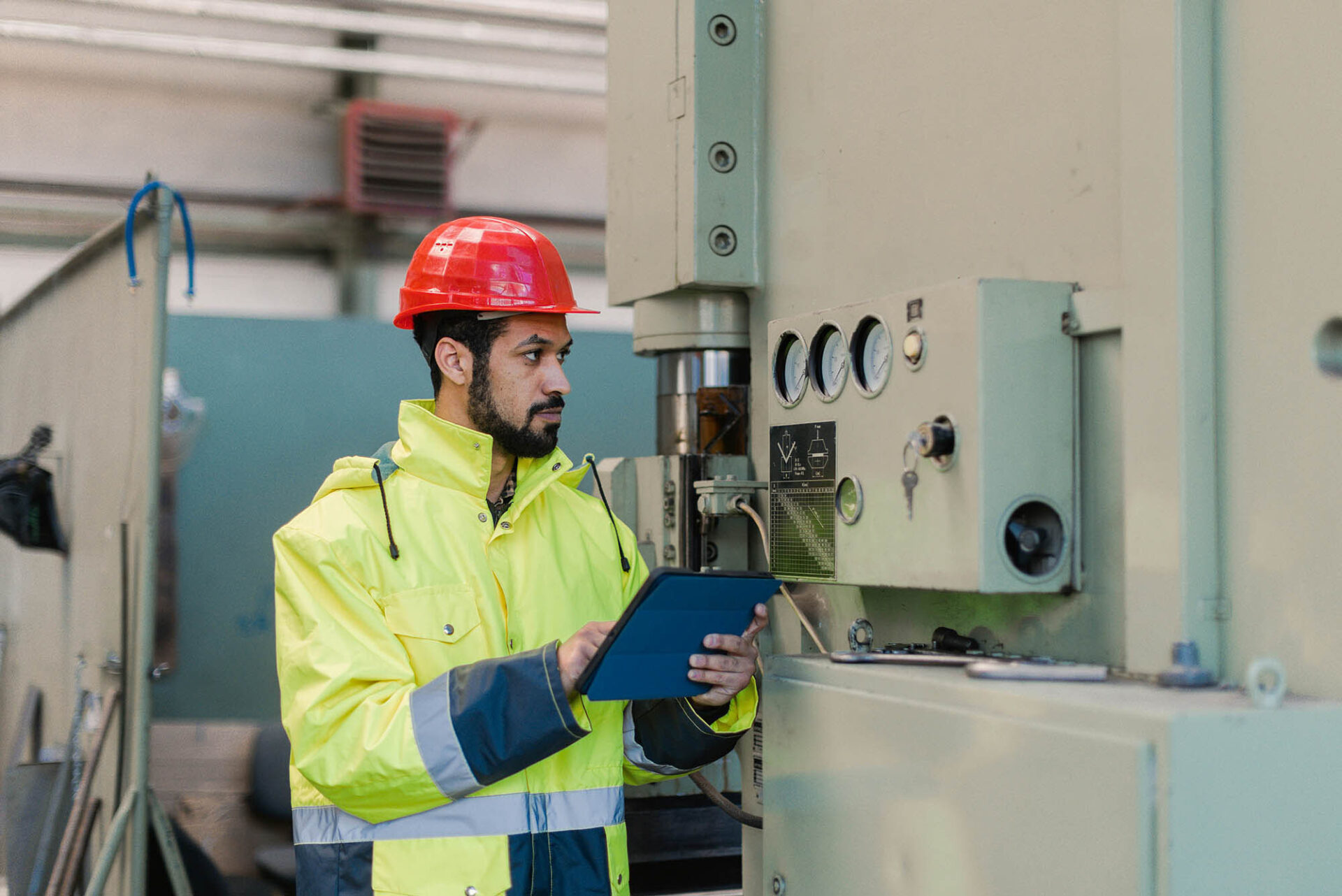 Engineer in power and utilities sector using tablet to manage financial close management tasks at industrial site